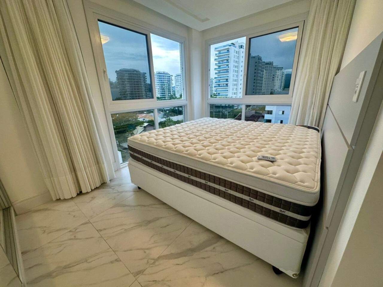 Apartamento à venda no Praia Brava: Suíte com janelas de canto e vista para os prédios da Brava