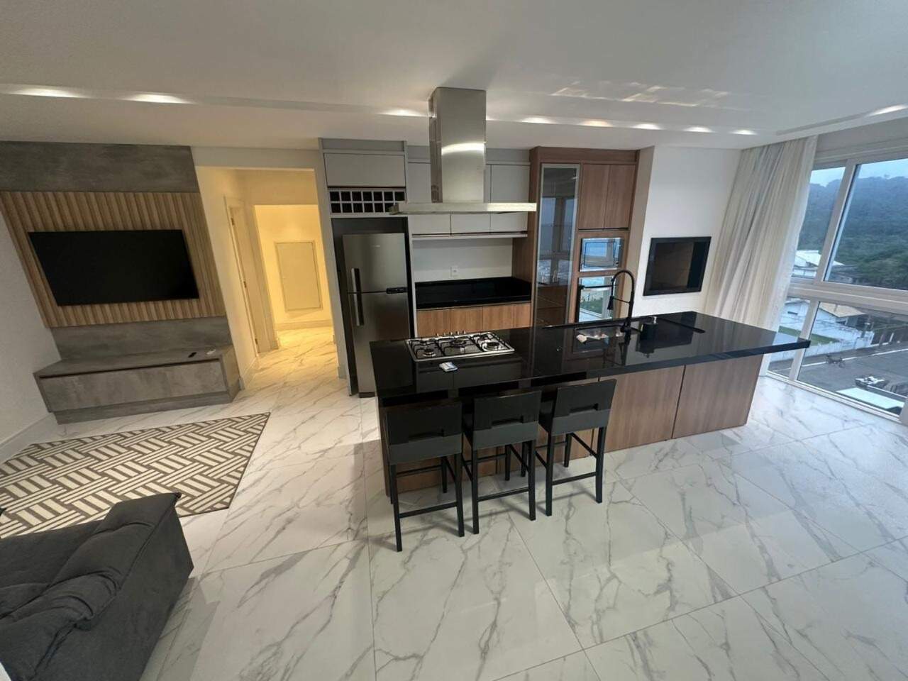 Apartamento à venda no Praia Brava: Living integrado à cozinha, com painel de TV e piso em porcelanato