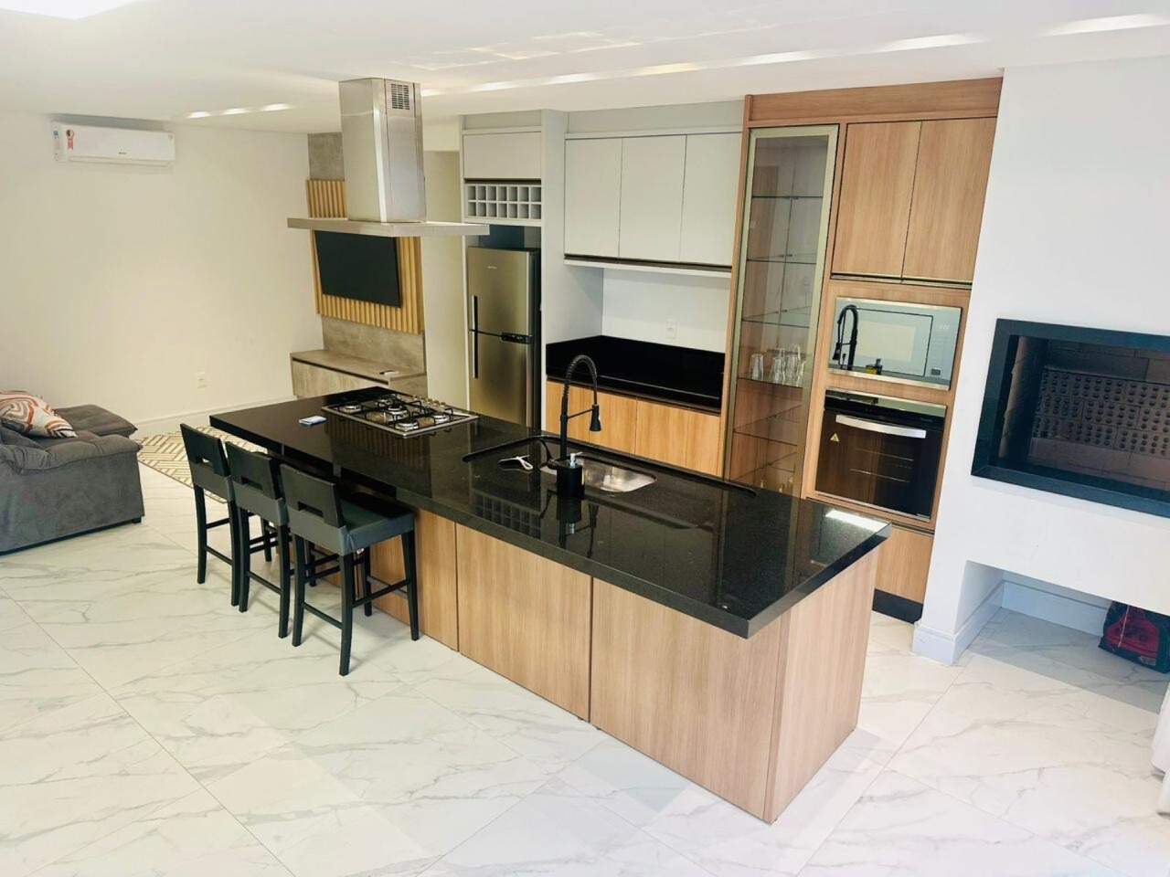 Apartamento à venda no Praia Brava: Cozinha com ilha, cooktop e marcenaria em madeira