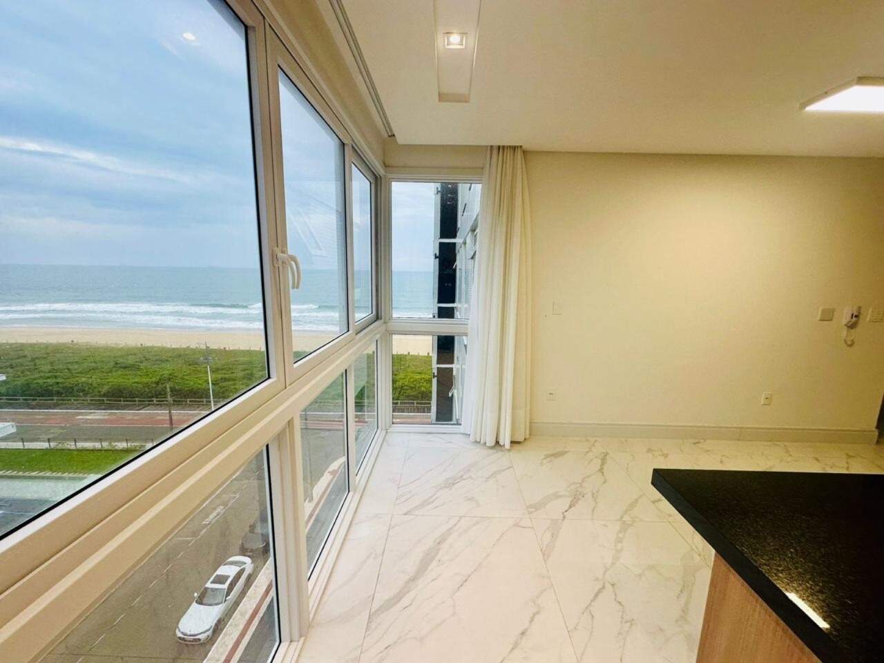 Apartamento à venda no Praia Brava: Living com janelas de canto e vista lateral para o mar da Praia Brava