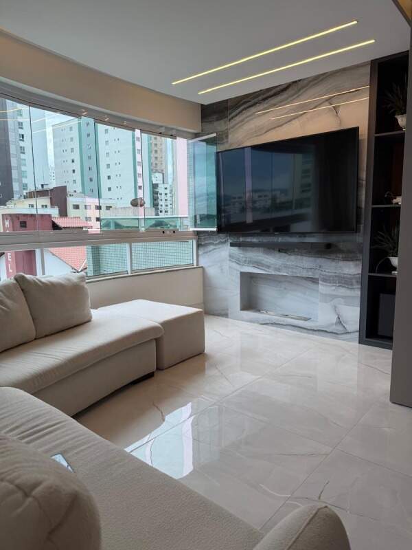 Apartamento à venda no Centro: Living com sofá, painel de mármore e TV