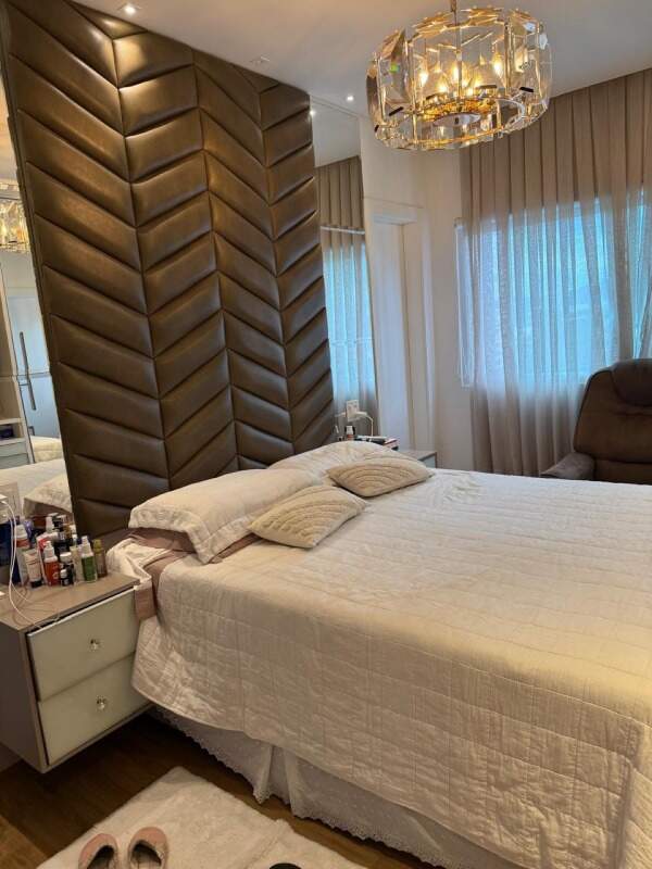 Apartamento à venda no Centro: Suíte com cabeceira estofada e lustre de cristal
