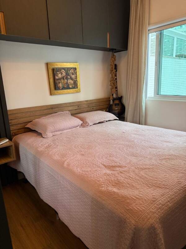 Apartamento à venda no Centro: Suíte com cabeceira de madeira e armário aéreo