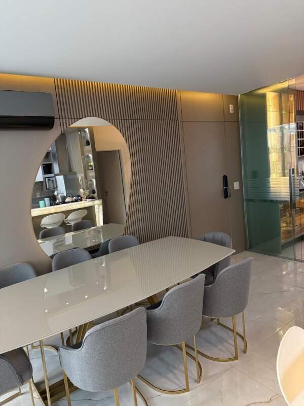 Apartamento à venda no Centro: Mesa de jantar com painel ripado e espelho redondo
