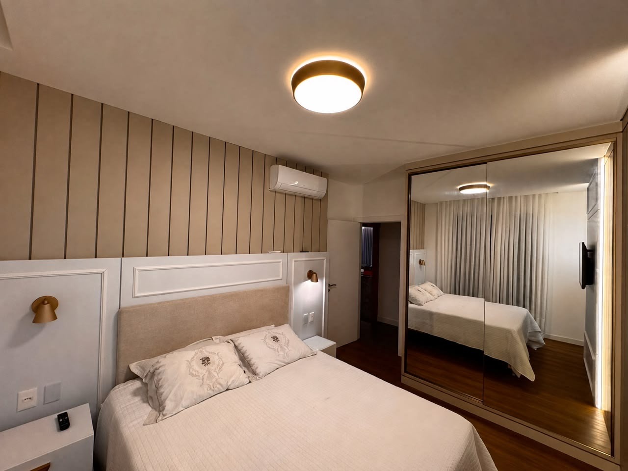 Apartamento à venda no Centro: Suíte com boiserie, cabeceira estofada e armário de portas espelhadas