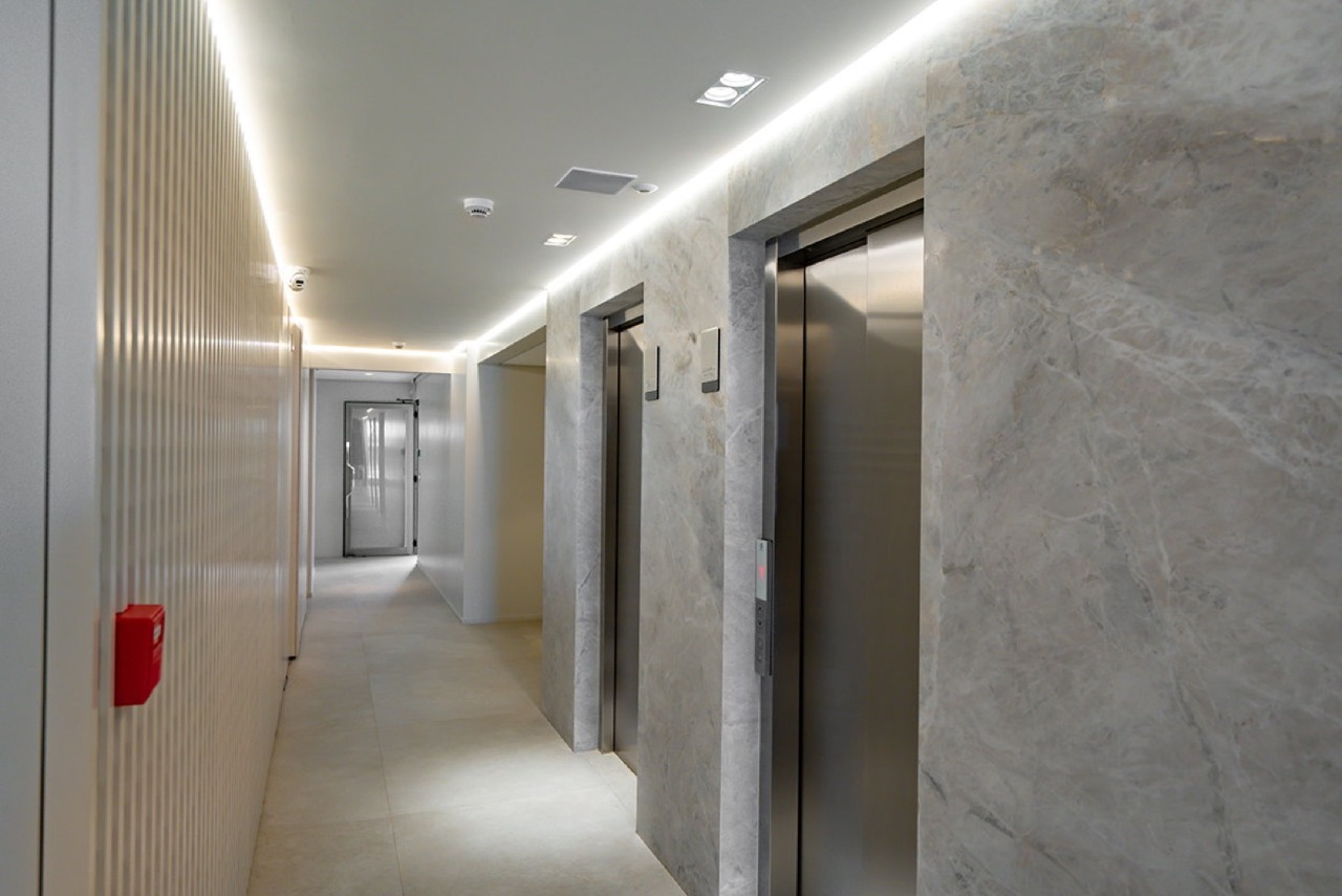 Cobertura à venda no Praia Brava: Hall dos elevadores com revestimento de pedra
