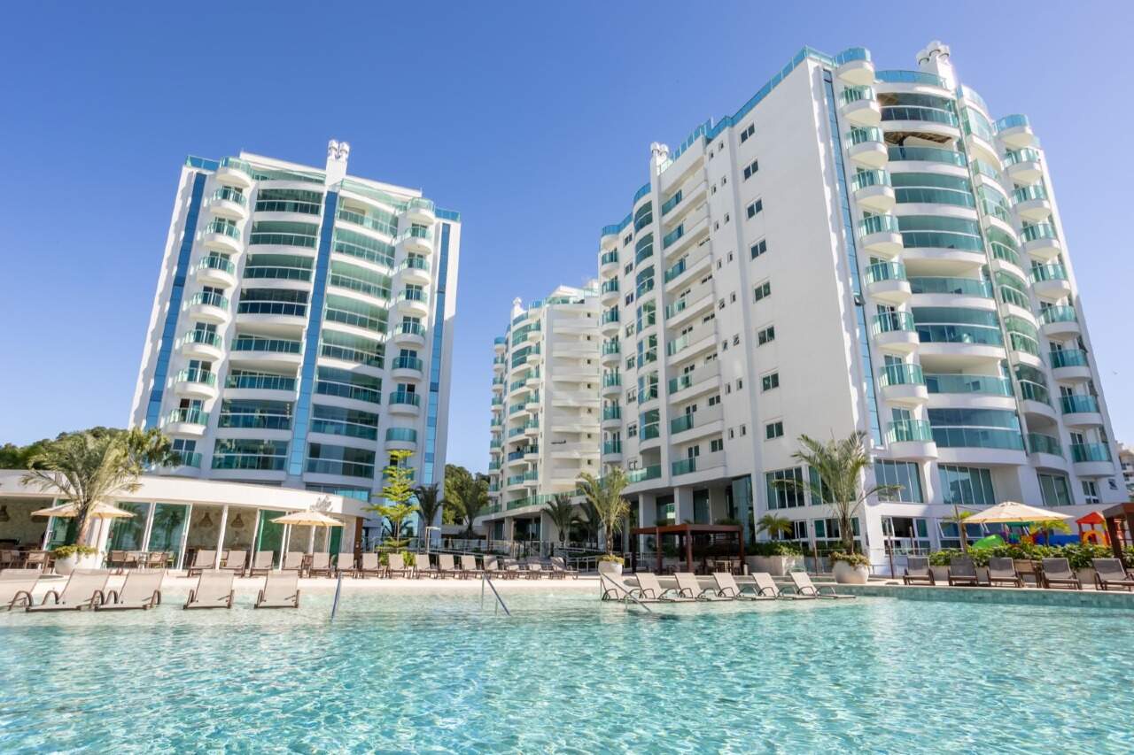 Apartamento à venda no Praia Brava: Piscina com prainha, espreguiçadeiras e as torres do Reserva Figueira
