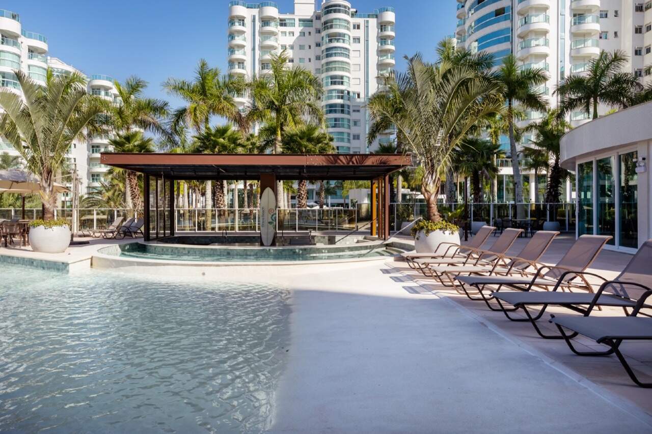 Apartamento à venda no Praia Brava: Piscina com quiosque de madeira entre palmeiras