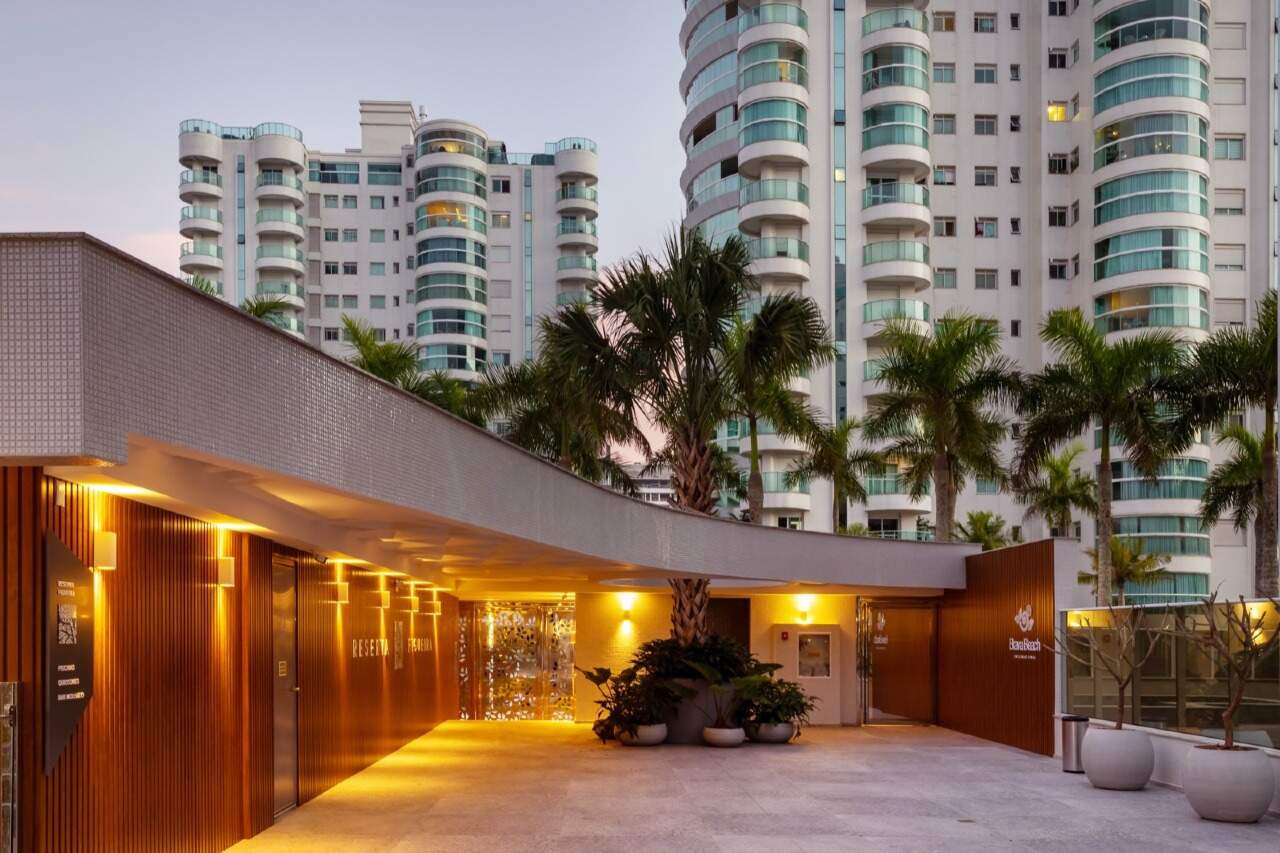 Apartamento à venda no Praia Brava: Acesso social iluminado entre jardins e palmeiras