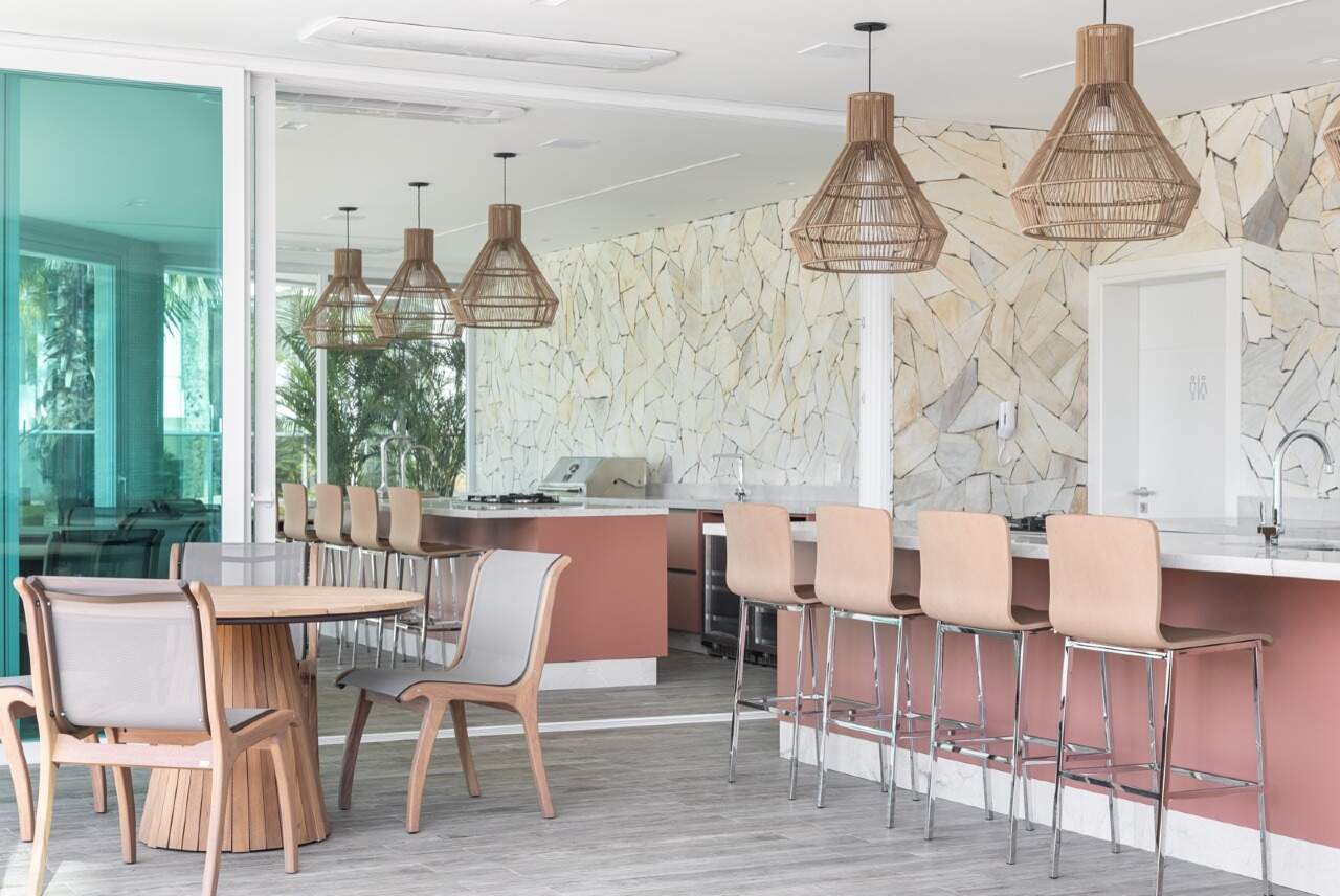 Apartamento à venda no Praia Brava: Espaço gourmet com bancada, banquetas e parede de pedra