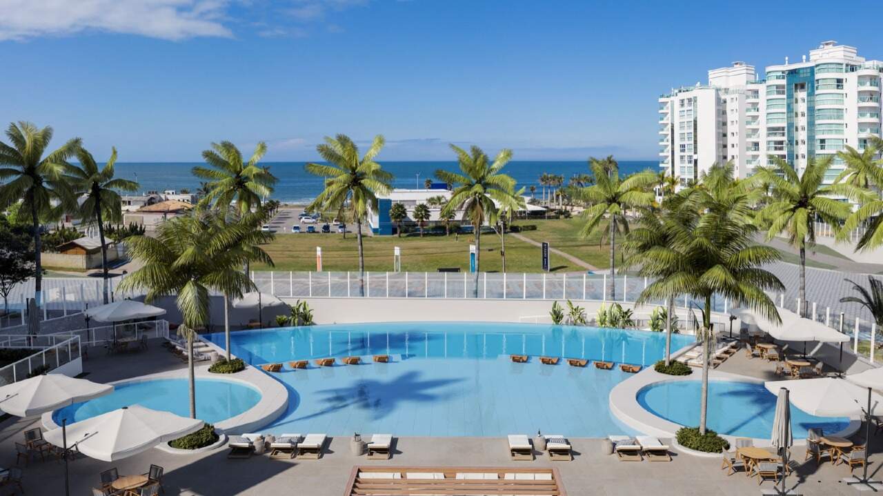 Apartamento à venda no Praia Brava: Piscinas externas com palmeiras e o mar ao fundo (imagem ilustrativa)