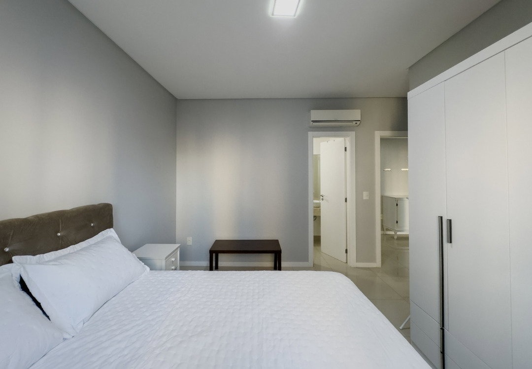 Apartamento à venda no Pioneiros: Suíte com cama de casal, guarda-roupa e ar-condicionado