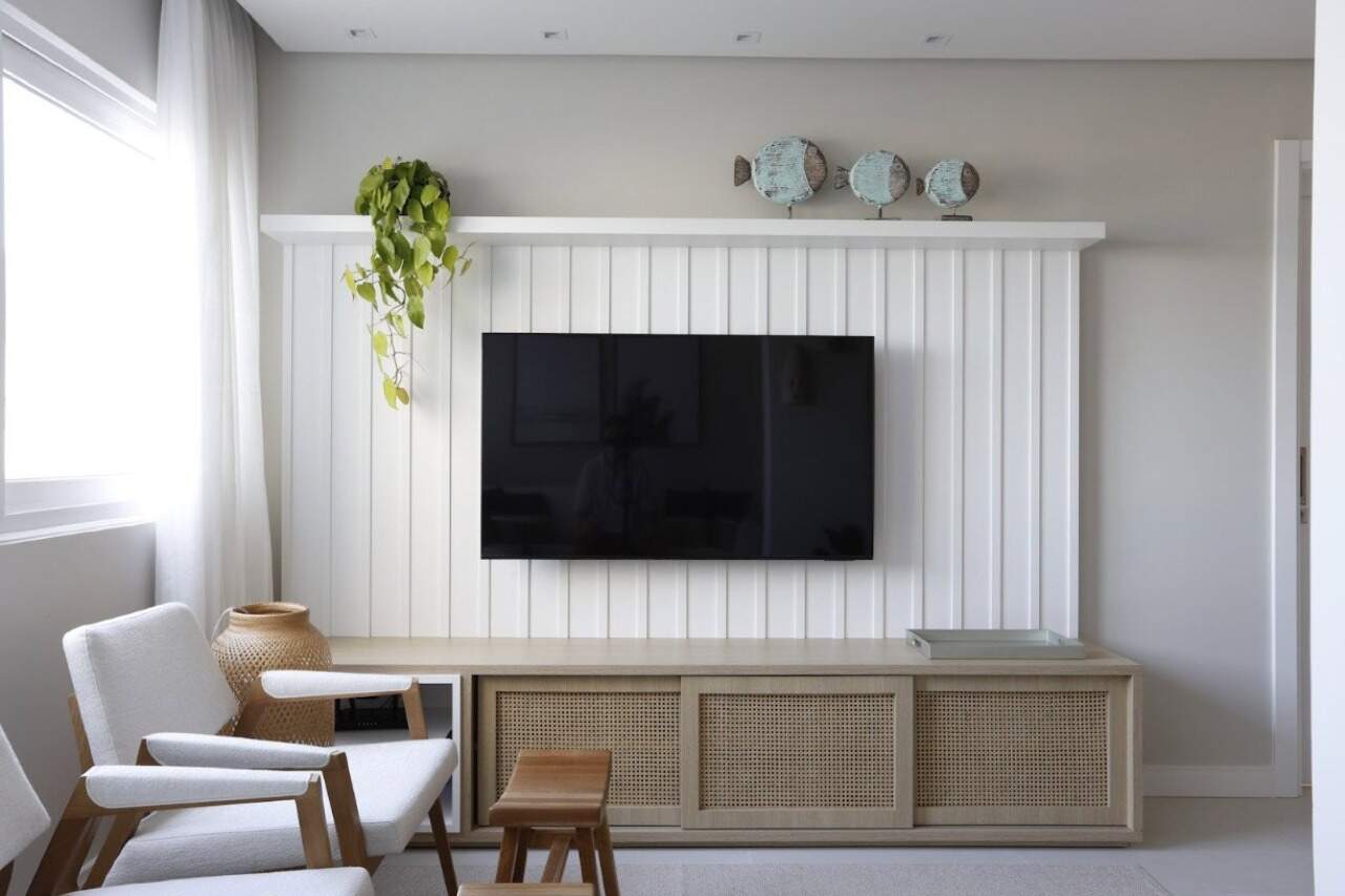 Apartamento à venda no Centro: Estar com painel ripado, TV e rack de madeira