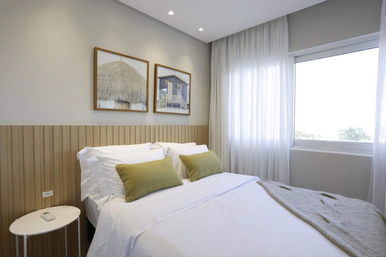 Apartamento à venda no Centro: Dormitório de casal com painel de madeira e janela
