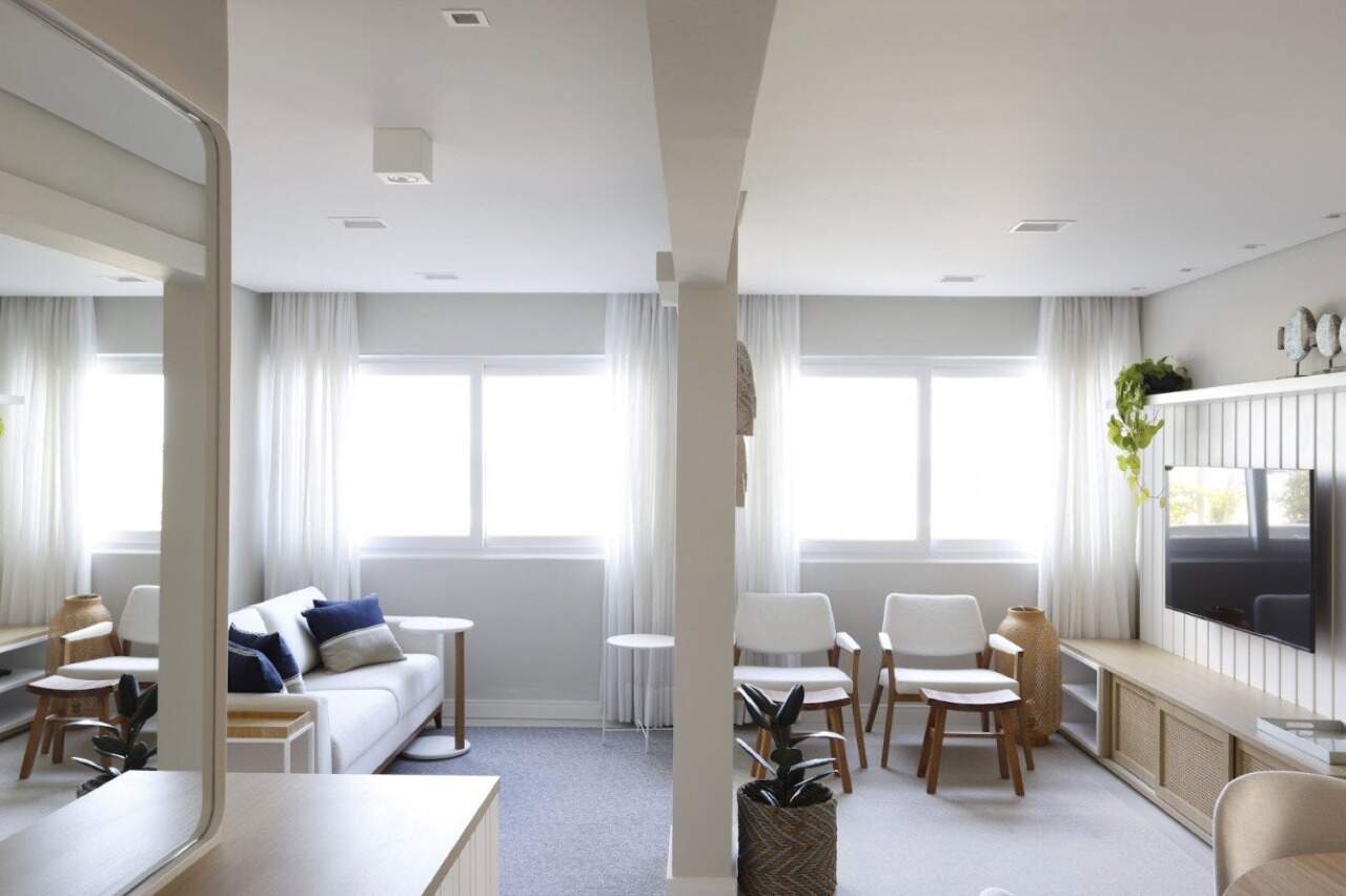 Apartamento à venda no Centro: Living amplo com sofá, poltronas e janelas largas
