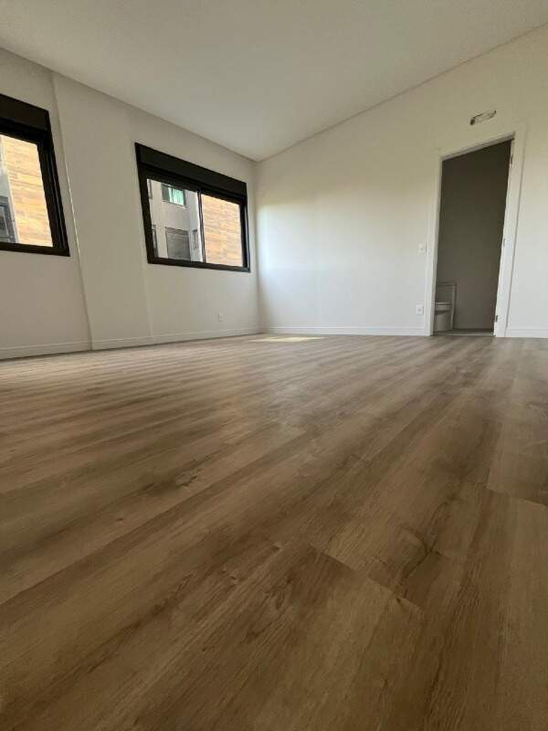 Apartamento diferenciado à venda no Praia Brava: Suíte com piso vinílico amadeirado e duas janelas (foto do apartamento)