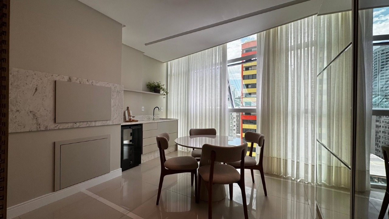 Apartamento à venda no Centro: Sacada integrada ao living, com bancada de pedra, cuba, adega e mesa redonda