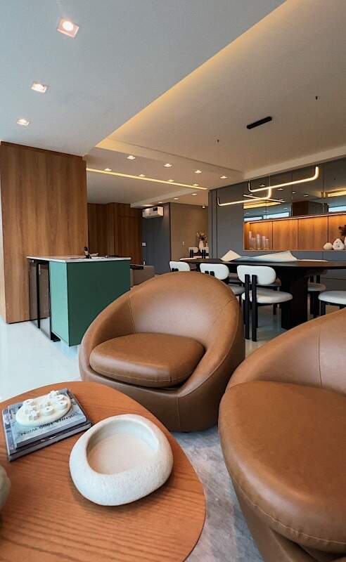 Apartamento à venda no Centro: Poltronas de couro com a sala de jantar e a cozinha atrás