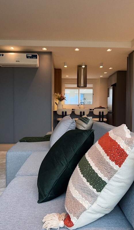 Apartamento à venda no Centro: Sofá com almofadas e a cozinha ao fundo