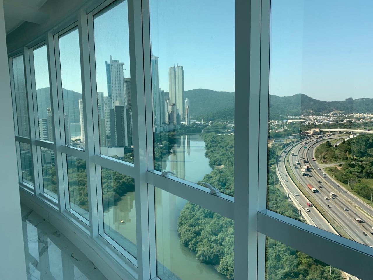 Apartamento à venda no Centro: Janela de canto com o Rio Camboriú, a BR-101 e as torres da Barra Sul