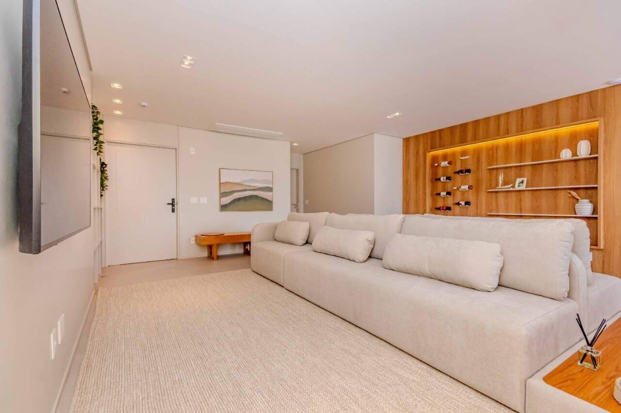 Apartamento à venda no Praia Brava: Living com estante de madeira iluminada