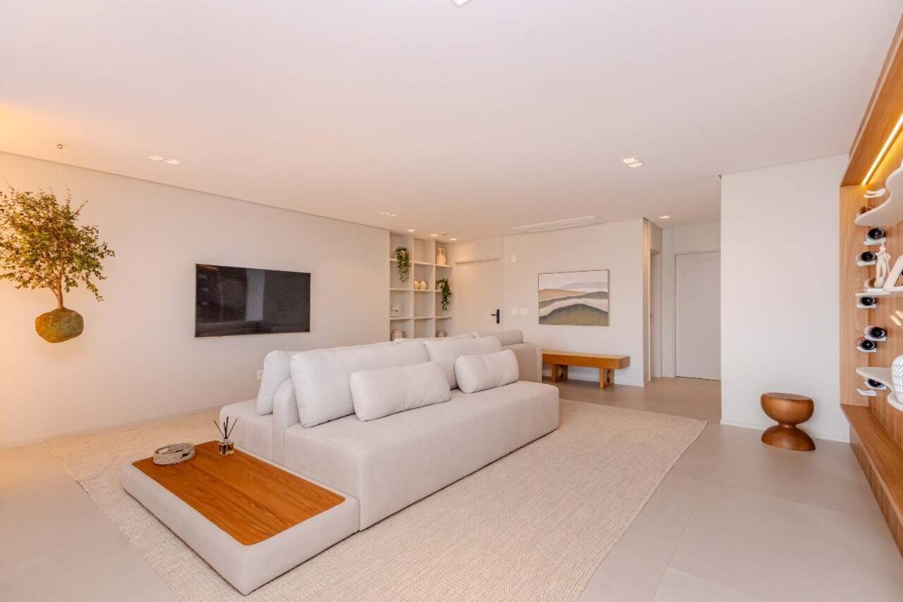 Apartamento à venda no Praia Brava: Living decorado com sofá, TV e nichos iluminados