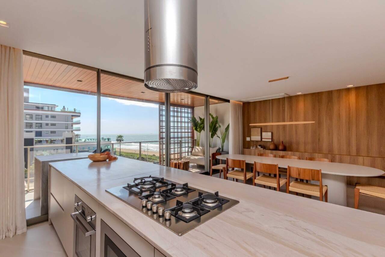 Apartamento à venda no Praia Brava: Cooktop na ilha, com o jantar e o mar ao fundo