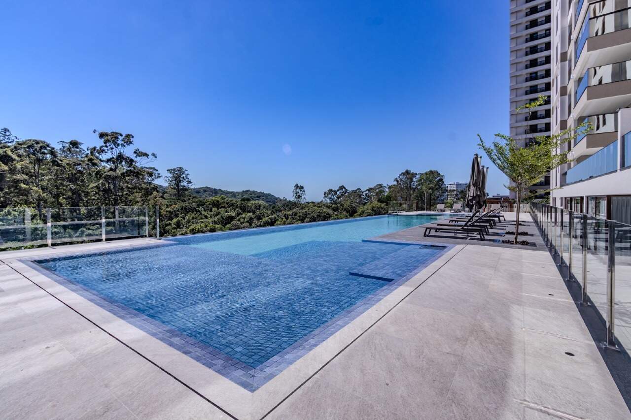 Apartamento à venda no Praia Brava: Piscina do Torres da Brava Sirena com os morros de Mata Atlântica ao fundo