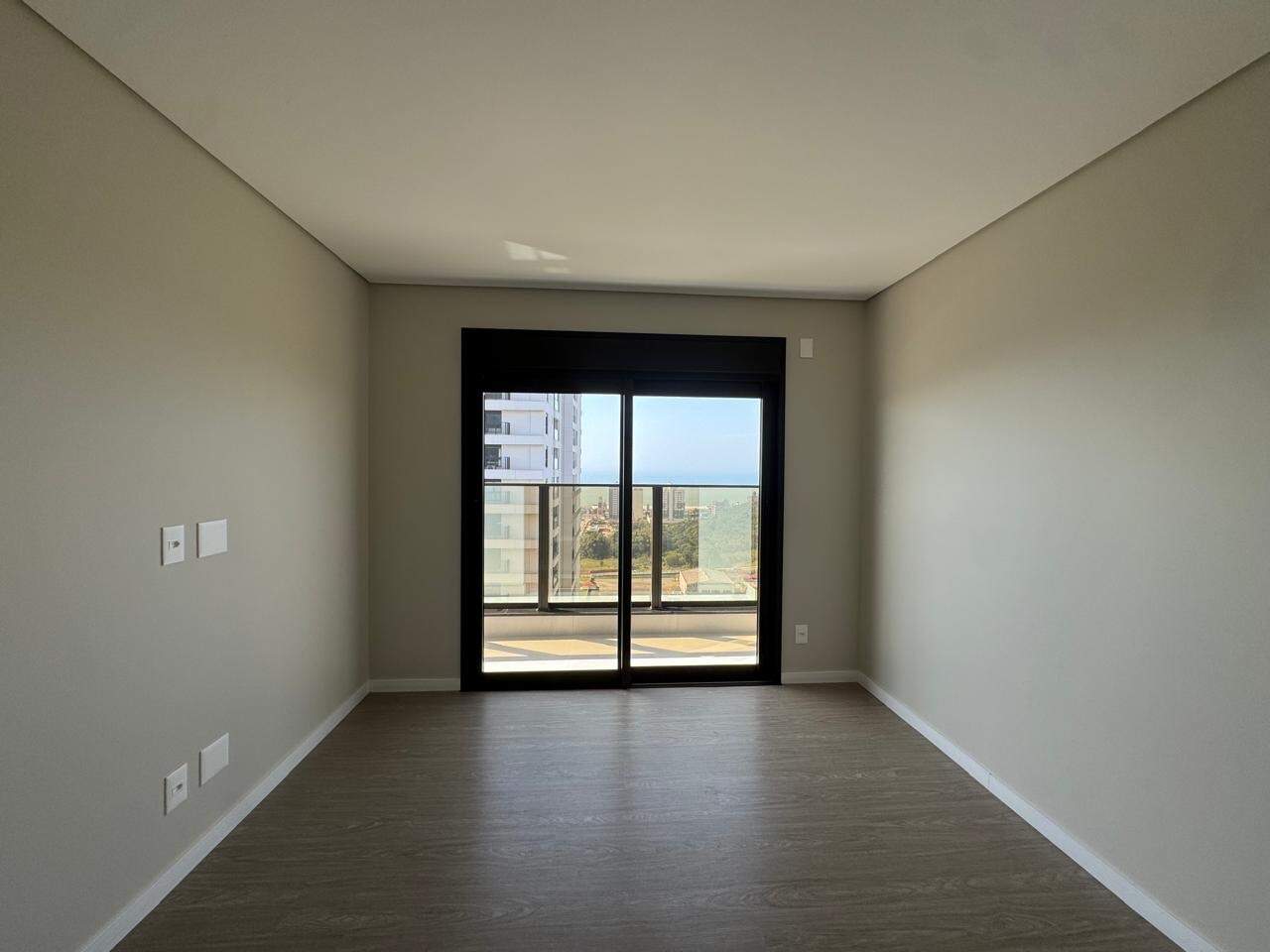 Apartamento à venda no Praia Brava: Suíte do Torres da Brava Sirena com porta de correr para a sacada e o mar ao fundo