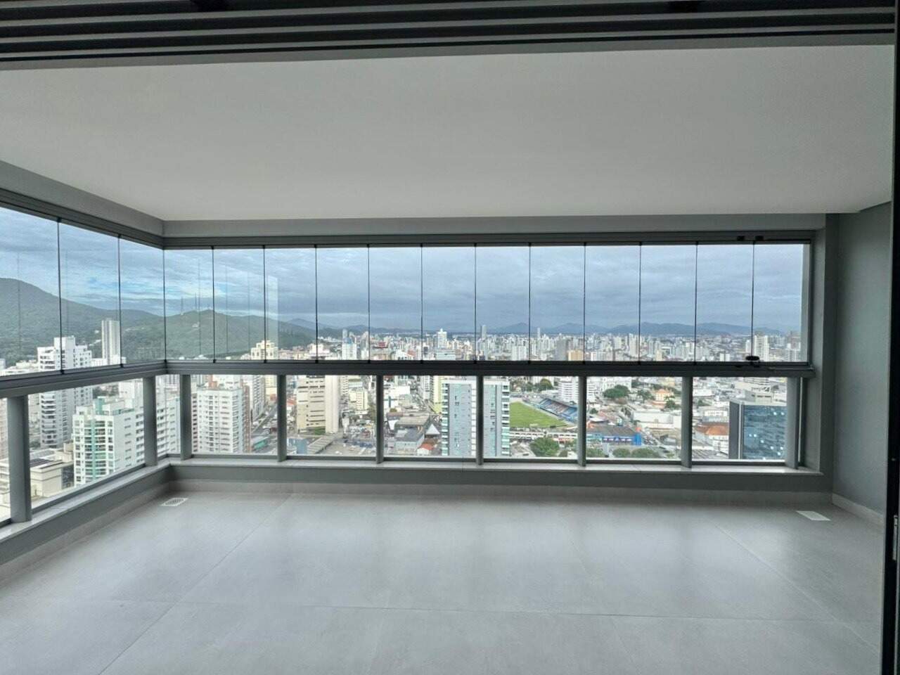 Apartamento à venda no Centro: Sacada envidraçada com vista para o Centro de Itajaí e o Estádio Hercílio Luz