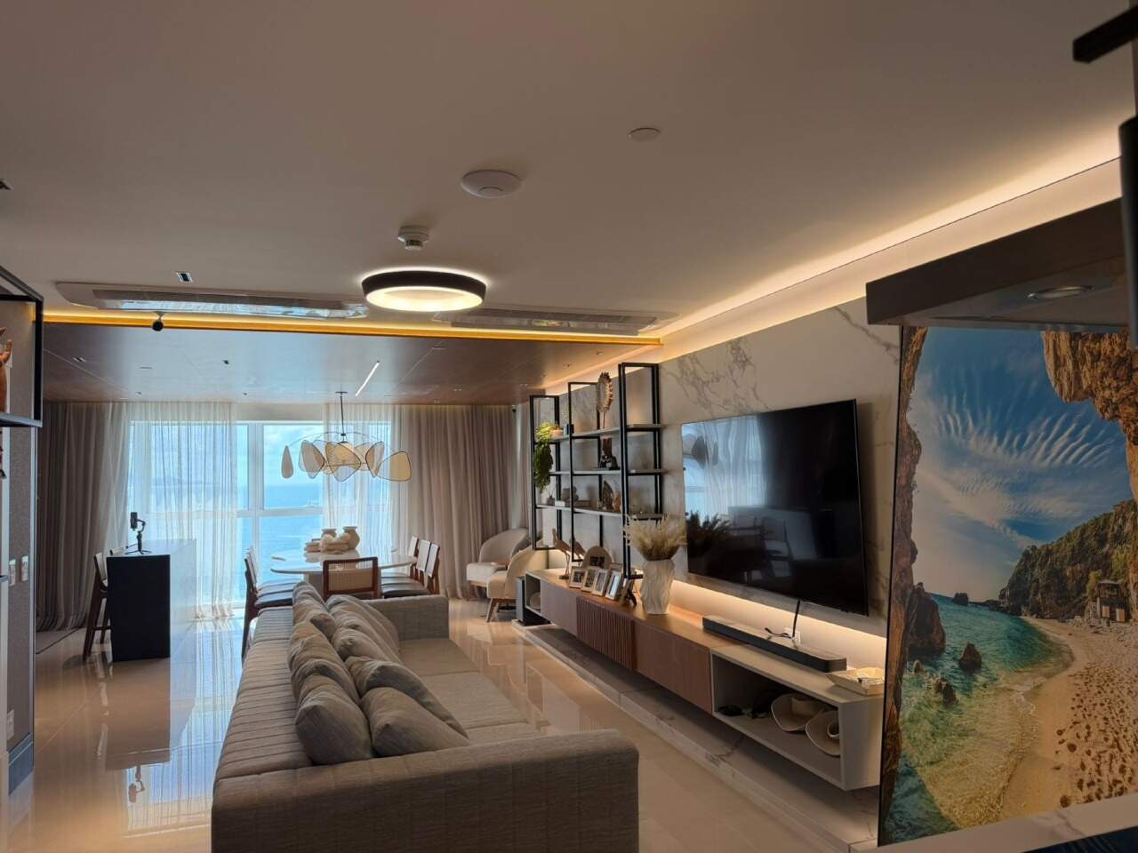 Apartamento à venda no Barra Sul: Living do apartamento de 196 m² no One Tower, com painel de TV e o mar ao fundo