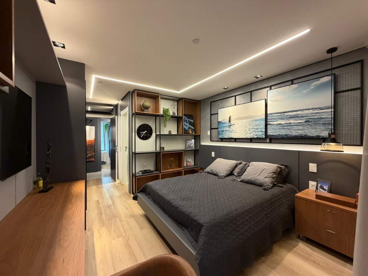 Apartamento à venda no Barra Sul: Suíte com cama de casal, estante e quadros de mar sobre a cabeceira