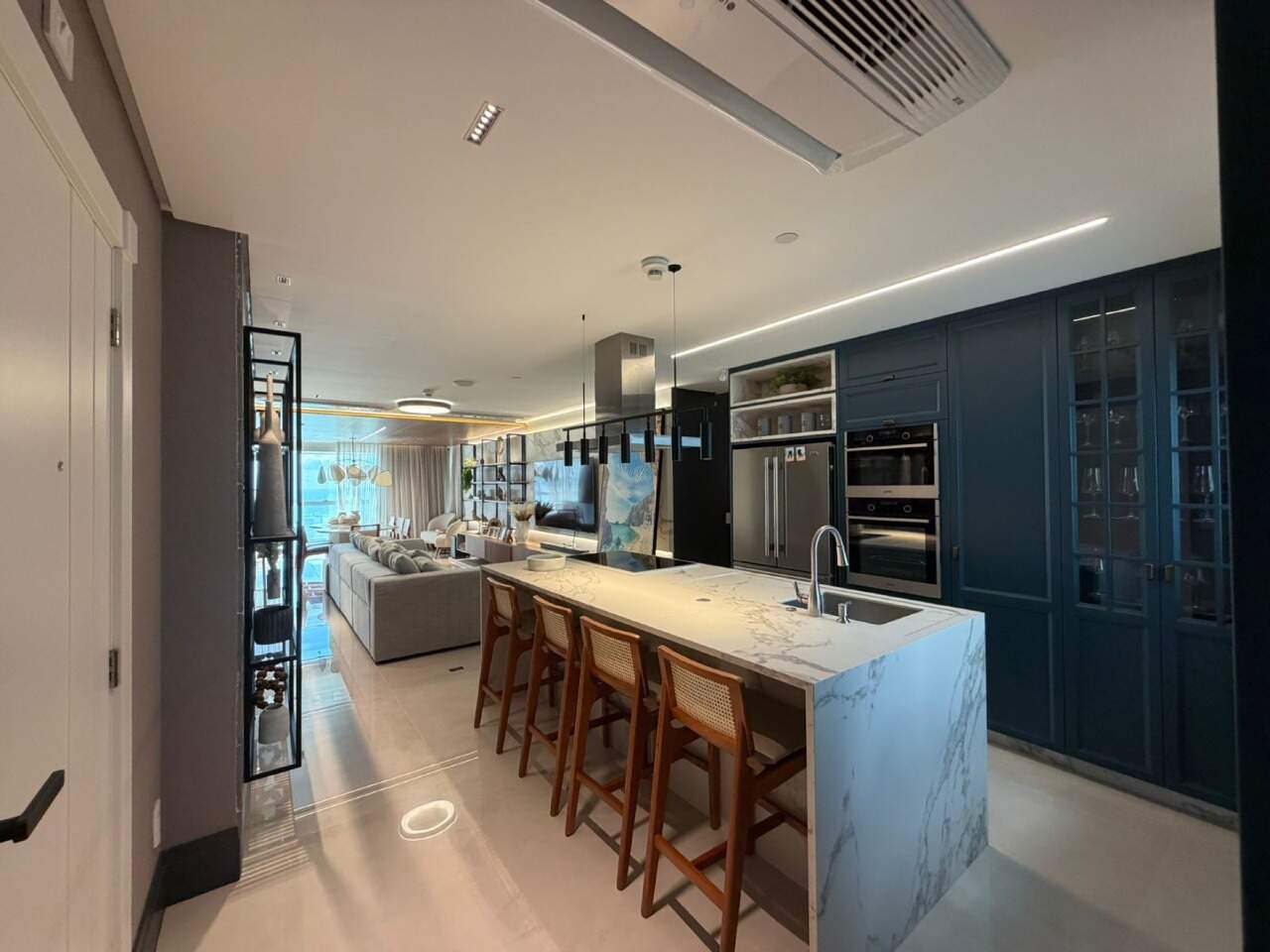 Apartamento à venda no Barra Sul: Cozinha com ilha, banquetas, armários planejados azuis e fornos de embutir