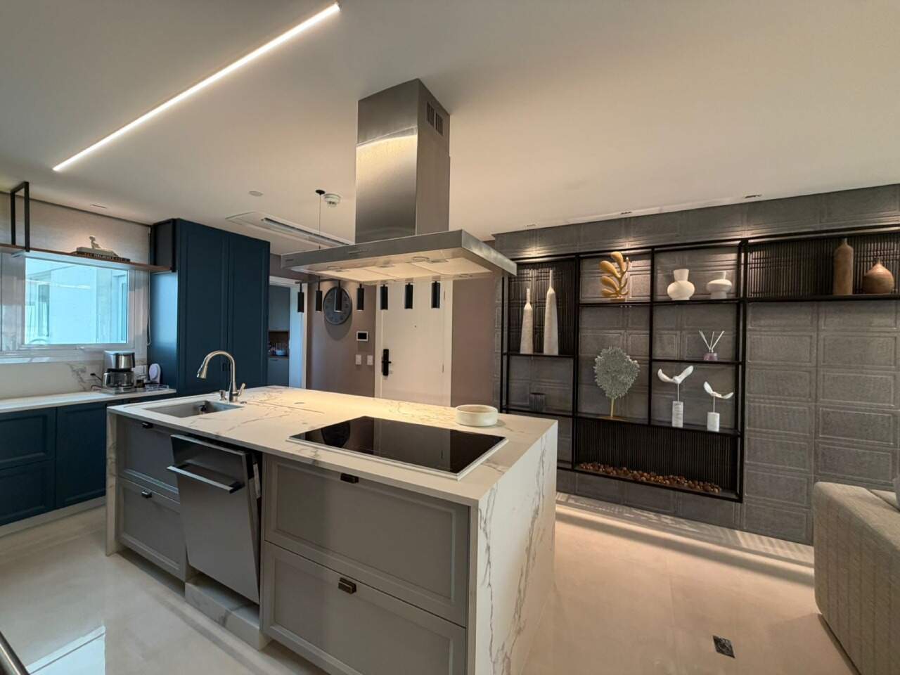 Apartamento à venda no Barra Sul: Cozinha com ilha em pedra clara, cooktop e coifa de inox