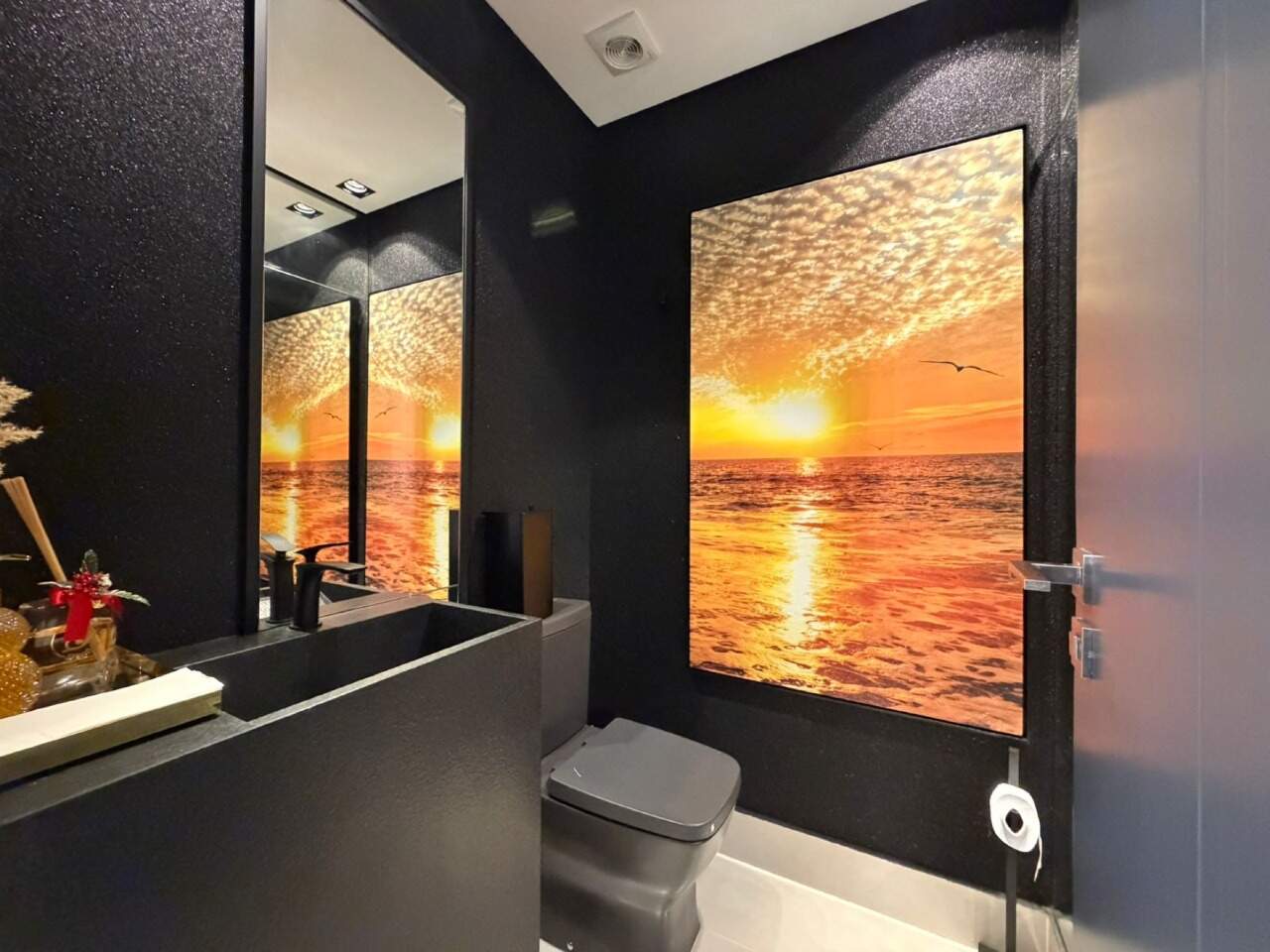 Apartamento à venda no Barra Sul: Lavabo com cuba escura e painel de pôr do sol