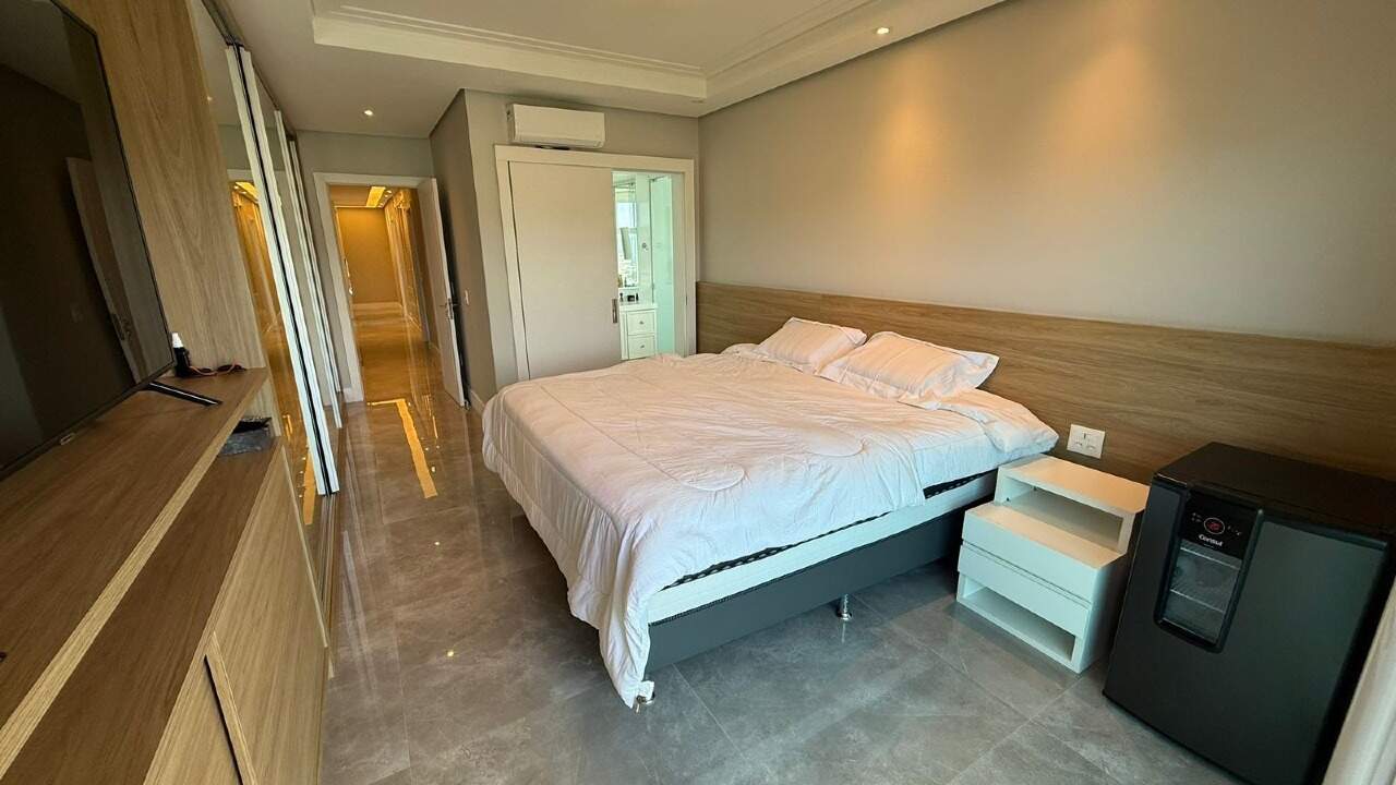 Apartamento à venda no Barra Sul: Suíte com cabeceira de madeira, frigobar e acesso ao banheiro