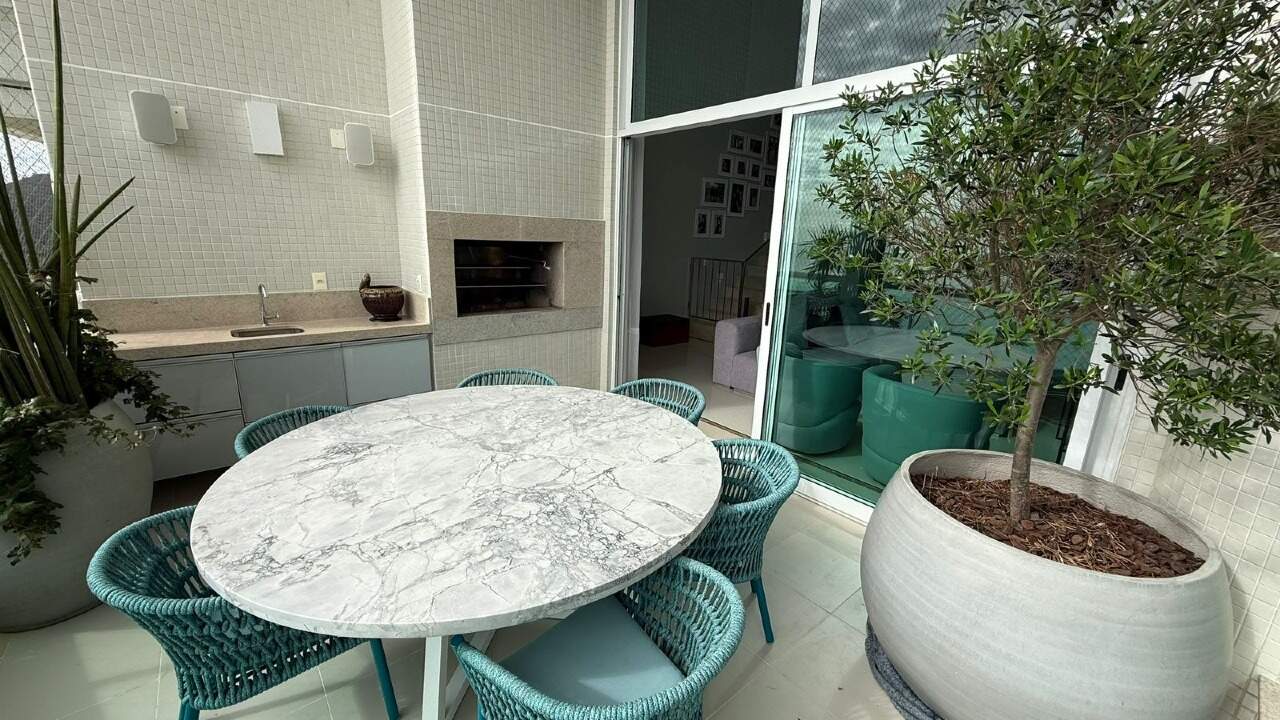 Apartamento à venda no Barra Sul: Mesa de mármore e churrasqueira na sacada do apartamento
