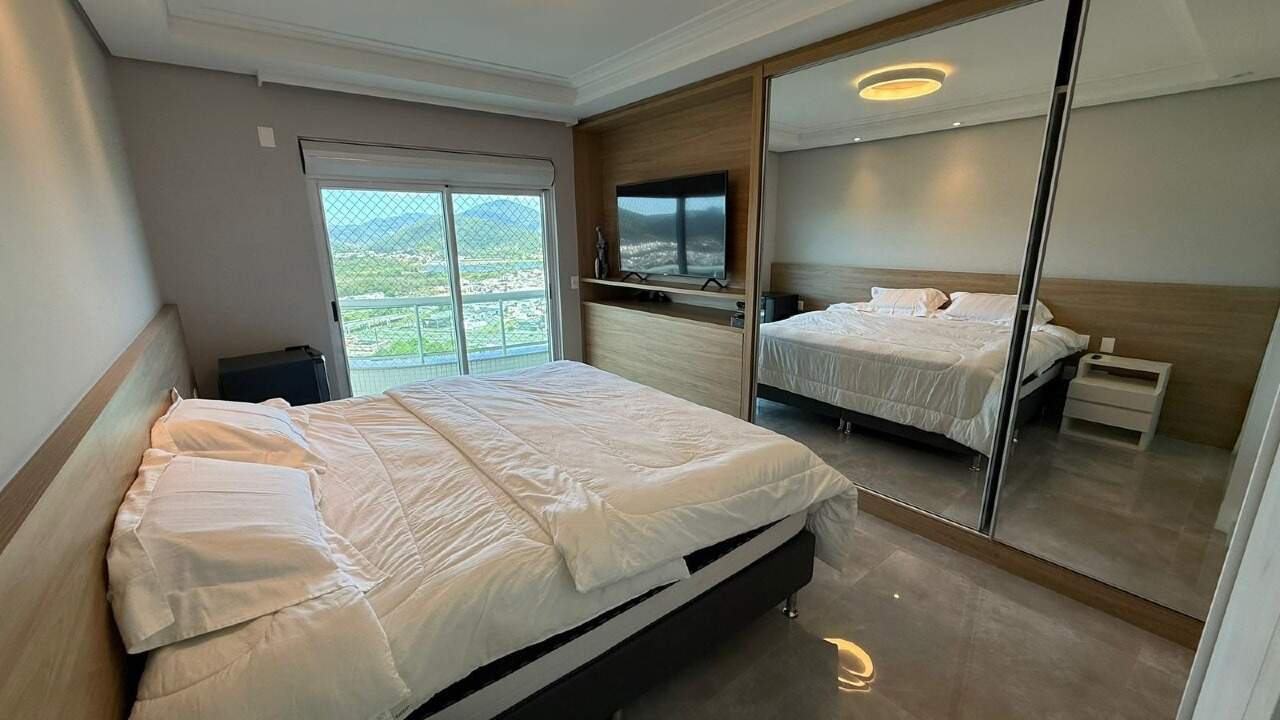 Apartamento à venda no Barra Sul: Suíte com armário espelhado, painel de TV e sacada