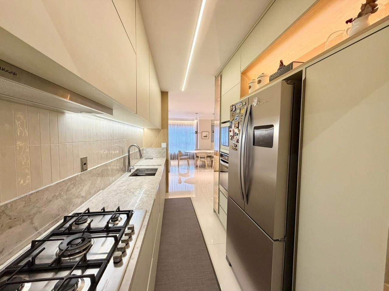 Apartamento à venda no Centro: Cozinha com cooktop a gás, bancada clara e geladeira