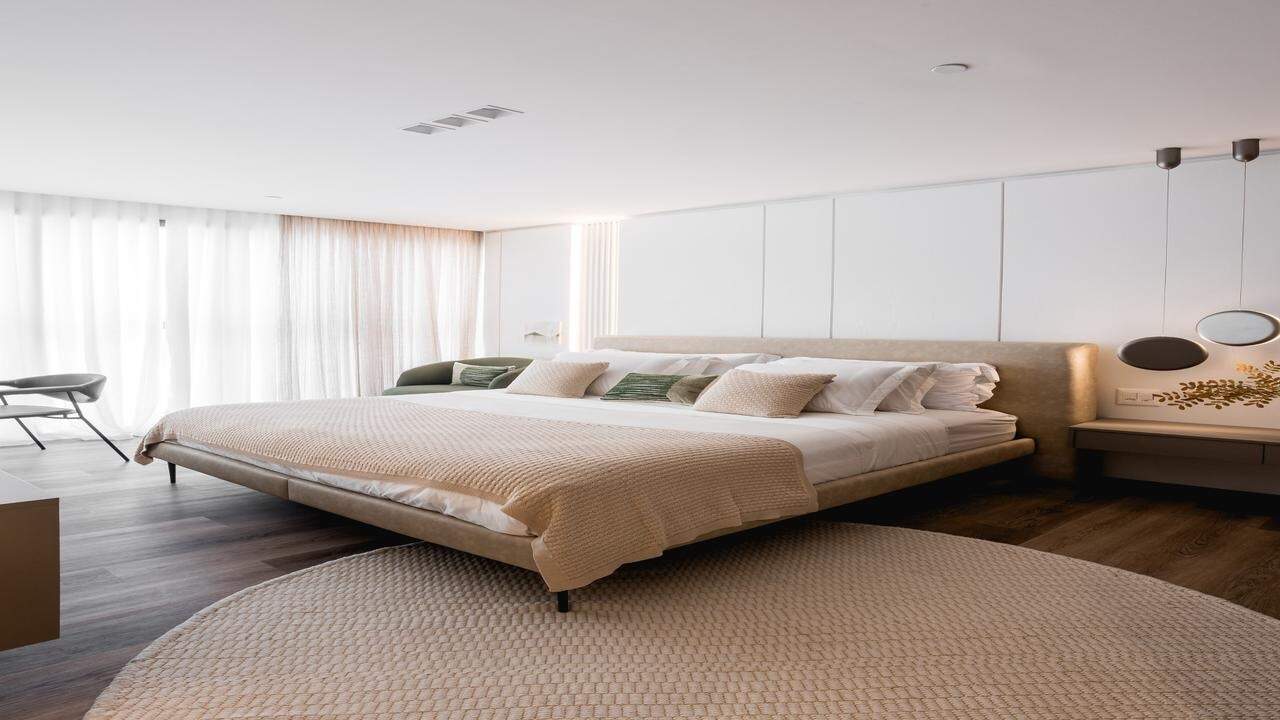 Apartamento diferenciado à venda no Centro: Suíte com cama baixa e tapete redondo (imagem ilustrativa)