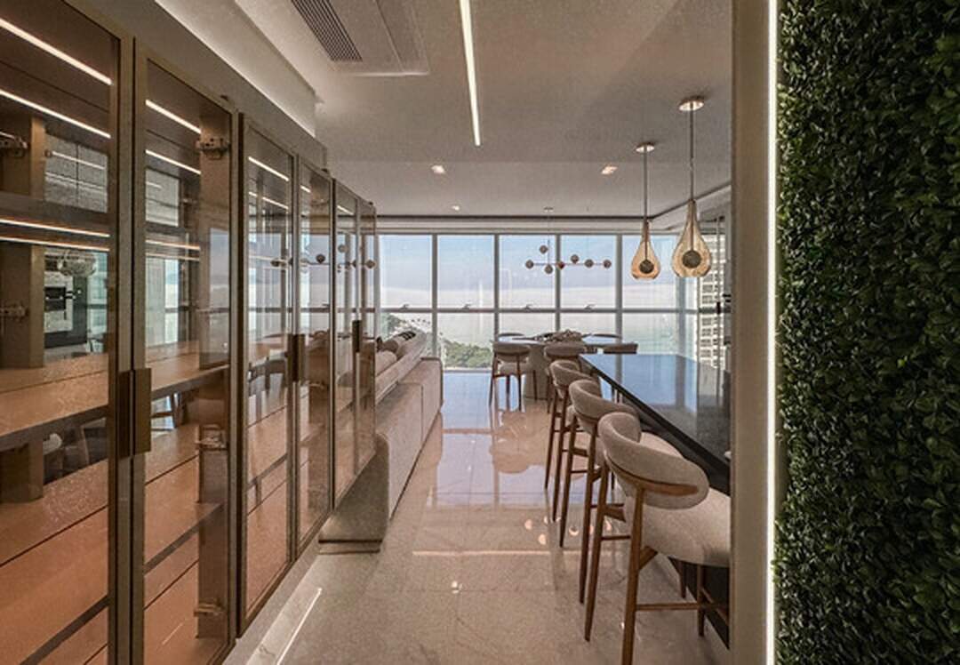 Apartamento à venda no Pioneiros: Cristaleiras de vidro e balcão com banquetas voltados para o living