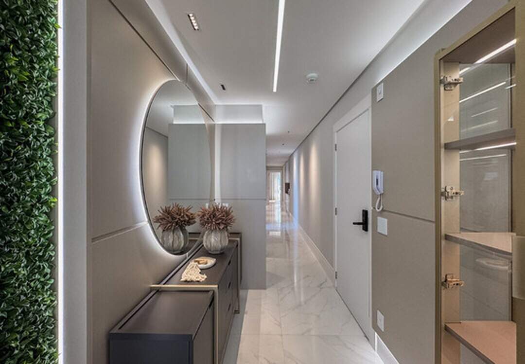 Apartamento à venda no Pioneiros: Hall de entrada com espelho redondo iluminado e jardim vertical