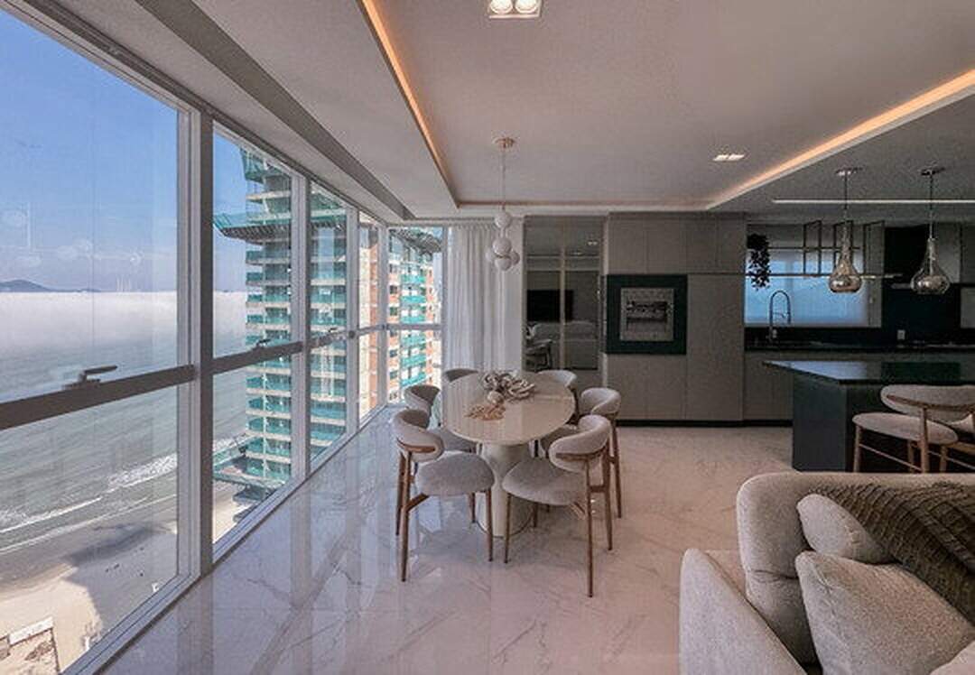 Apartamento à venda no Pioneiros: Living e jantar com janelas do piso ao teto e a praia lá embaixo