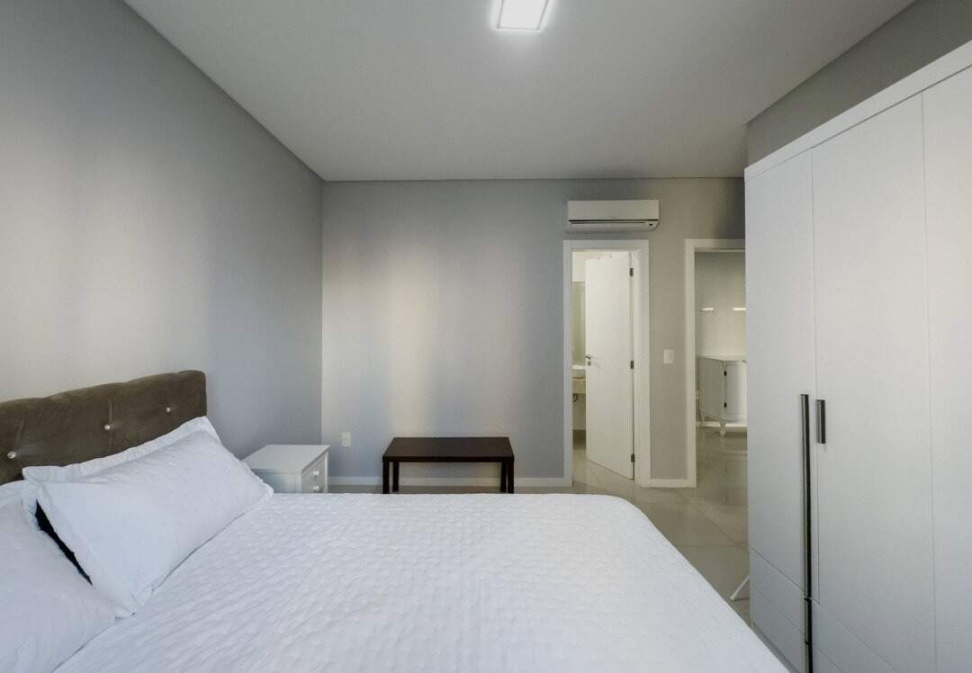 Apartamento à venda no Pioneiros: Suíte com cama de casal, guarda-roupa e ar-condicionado