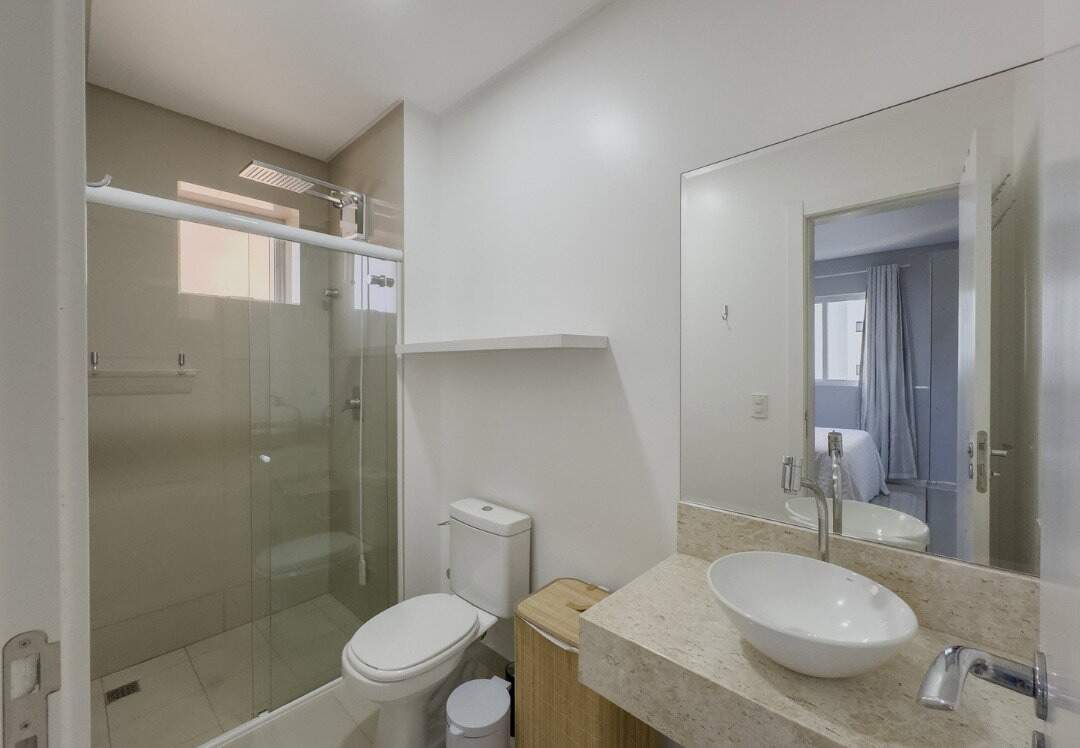 Apartamento à venda no Pioneiros: Banheiro da suíte com box de vidro e cuba de apoio sobre bancada de granito