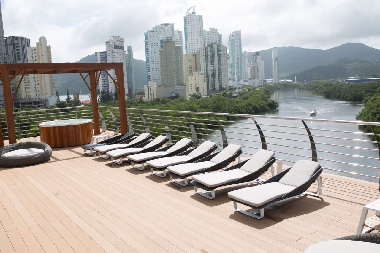 Apartamento à venda no Barra Sul: Deck com espreguiçadeiras, ofurô e vista para o Rio Camboriú