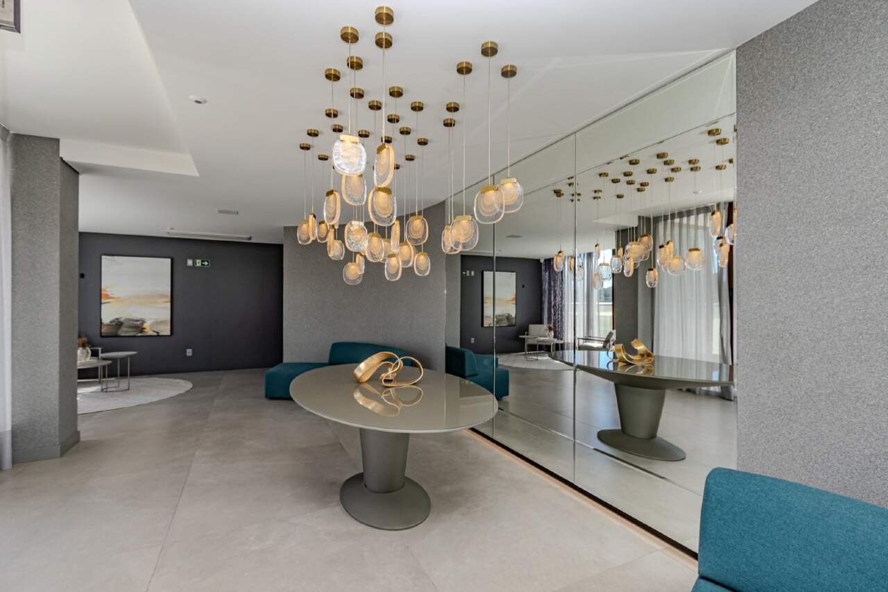 Apartamento à venda no Praia Brava: Salão com lustre de vidro e parede espelhada no Sirena