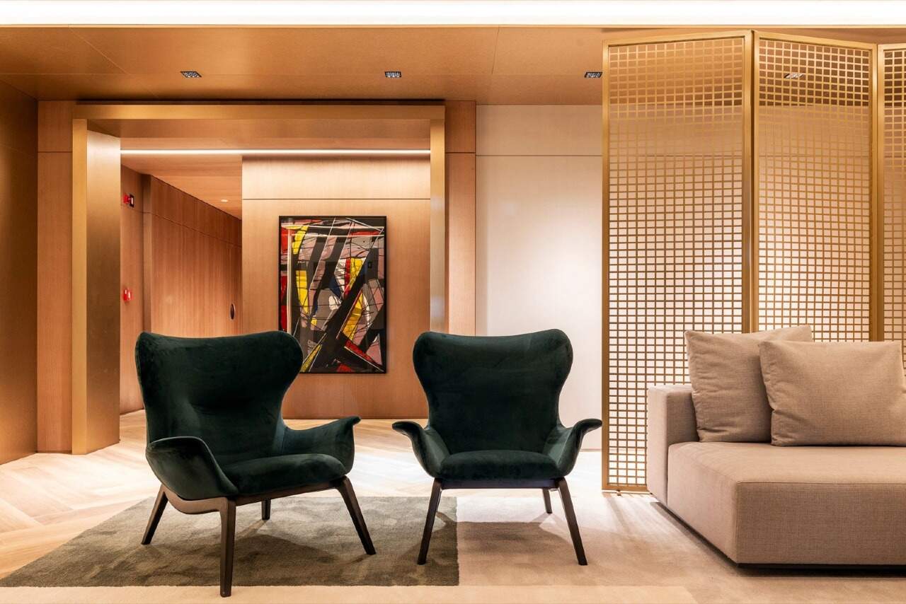 Apartamento à venda no Fazenda: Estar do hall de entrada, com poltronas verdes e painel de madeira
