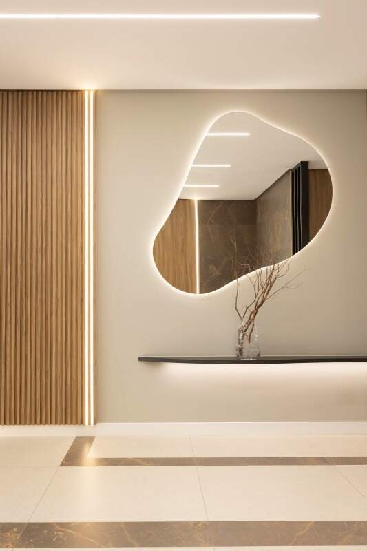 Apartamento diferenciado à venda no Fazenda: Hall com espelho orgânico e aparador iluminado