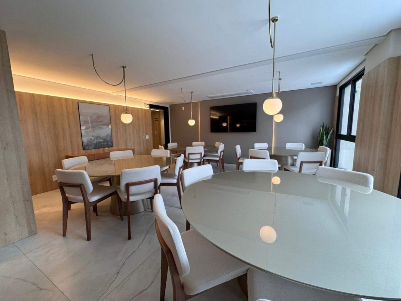 Apartamento à venda no Praia Brava: Salão de festas com mesas e decoração em madeira (foto real)